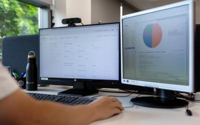 chico con una pantalla y un ordenador