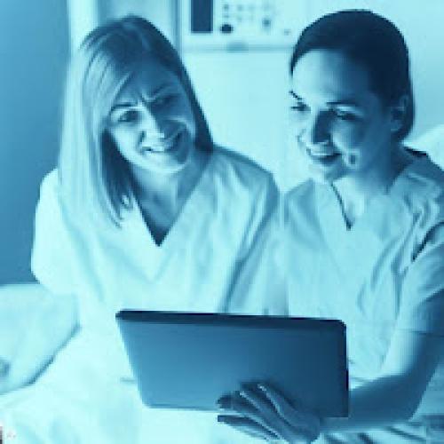 dos chicas sentadas mirando una tablet